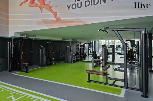 a gym with lots of machines and green carpet at 7 By Aurora 102 Jebel Ali in Dubai