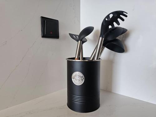 a black container filled with cooking utensils on a counter at 7 By Aurora 102 Jebel Ali in Dubai