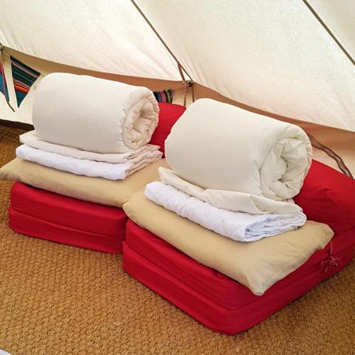 a pile of pillows sitting on top of red boxes at Fallow Fields Camping, Selson Farm in Eastry
