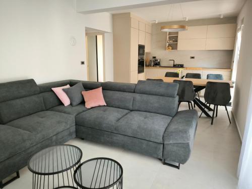 ein Wohnzimmer mit einem Sofa und einigen Tischen und Stühlen in der Unterkunft Luxury Apartments Marina View in Vodice
