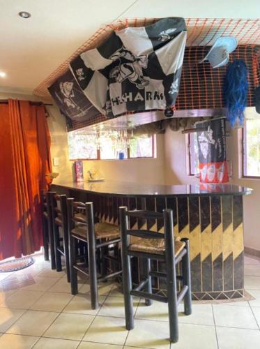 a bar with a bunch of chairs sitting at it at The Red room Serengeti sands in Phalaborwa