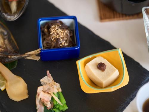 un tavolo con un piatto di cibo e una ciotola di cibo di Hotel Holistic Resort Wakayama a Taiji