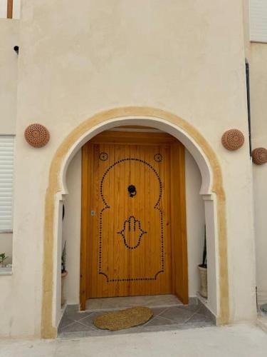 een toegang tot een gebouw met een houten deur bij Dar FATMA in Houmt Souk