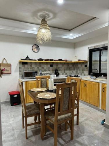 una cucina con tavolo e sedie e una cucina con fornelli di Dar FATMA a Houmt Souk