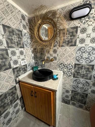 un bagno con lavandino e specchio di Dar FATMA a Houmt Souk