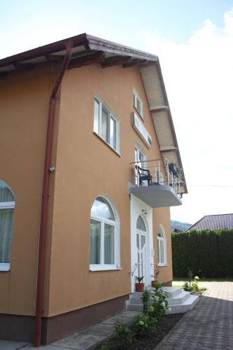 a house with a balcony on the side of it at Pensiunea Hyperion Cormaia in Sîngeorz-Băi