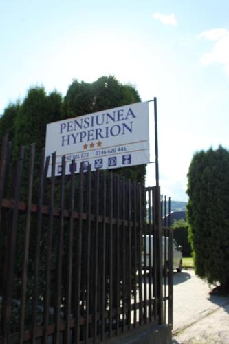 a sign on a fence in front of a building at Pensiunea Hyperion Cormaia in Sîngeorz-Băi