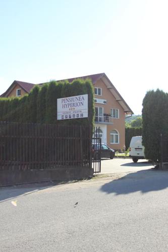 a sign on a fence in front of a house at Pensiunea Hyperion Cormaia in Sîngeorz-Băi