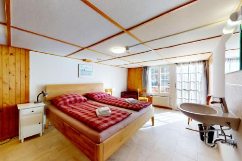 a bedroom with a bed and a sink in it at Gadmen Alpenrose, Switzerland in Gadmen