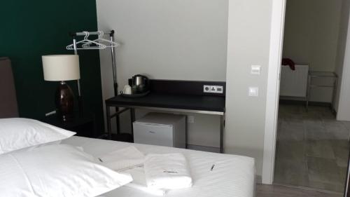 a bed with white sheets and a desk in a room at EdMont in Pietroşiţa