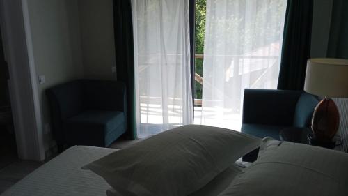 a bedroom with a bed and a chair and a window at EdMont in Pietroşiţa
