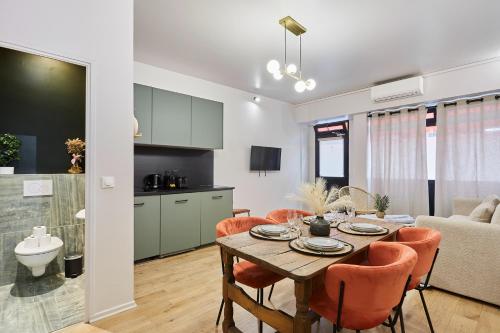 une cuisine et un salon avec une table et des chaises dans l'établissement Residence centre de Paris by Studio prestige, à Paris