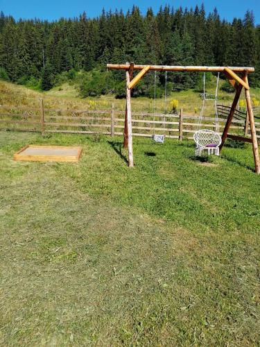 a swing set in the middle of a field at къщи за гости Под звездите in Pamporovo