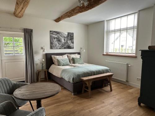 a bedroom with a bed and a table and a couch at B&B de Perenboom in Eck en Wiel