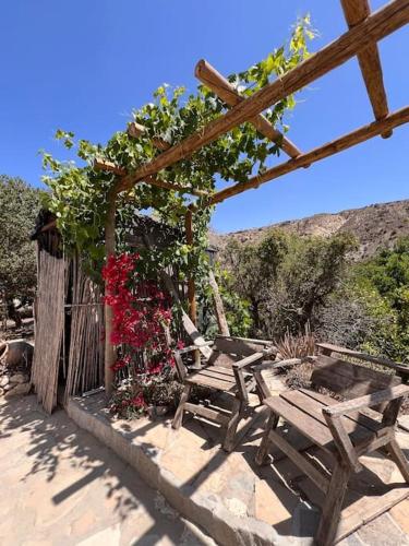 a wooden bench sitting on a patio with flowers at CASA LEÓN - Freistehendes Gästehaus mit 3 Zimmer, Vivienda Rural VTARAL01089 in Sorbas