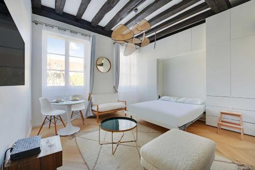 un salon avec un lit et une table dans l'établissement Authentic studio - 2P - Hôtel de Ville, à Paris