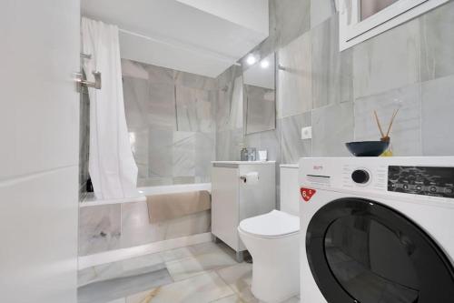 ein weißes Bad mit einer Waschmaschine in der Unterkunft Duplex marinero con vista al mar gimnasio piscina - LAS ABEJERAS 615 in Estepona