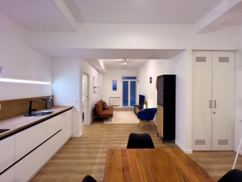 圣塞瓦斯蒂安MILA I Local Rentss的配有白色橱柜和木桌的厨房