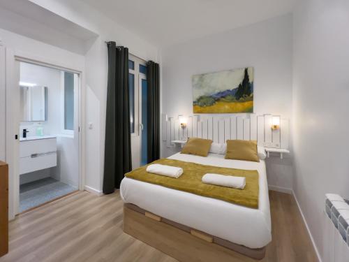 圣塞瓦斯蒂安MILA I Local Rentss的白色的卧室设有一张大床和一间浴室。