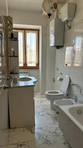 a white bathroom with a toilet and a sink at Il borgo di Mefila, La casa in Corte in Scandriglia