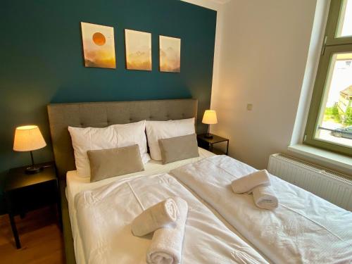 a bedroom with a bed with towels on it at Apartments am Markt in Angermünde