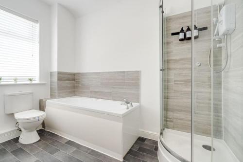Un baño con bañera, inodoro y ducha. en Park House - By Sigma Stays, en Crewe