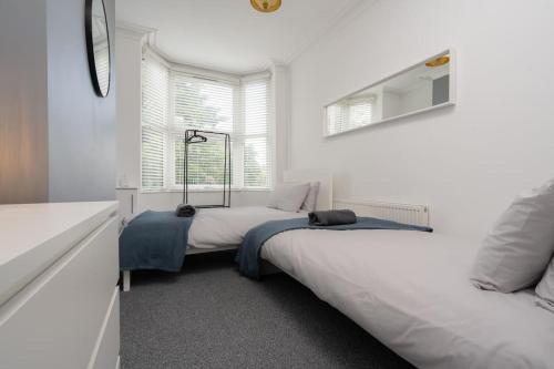 Un dormitorio con dos camas y una ventana. en Park House - By Sigma Stays, en Crewe