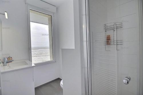 une salle de bain avec une douche et un lavabo et une fenêtre dans l'établissement BELLEVUE Belle maison en front de mer, au Crotoy