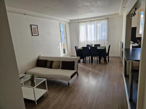 un salon avec un canapé et une table dans l'établissement Bel et lumineux Appartement - Sannois, à Sannois