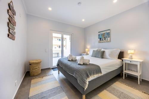 a bedroom with a large bed and a window at O Golfinho in Lagos