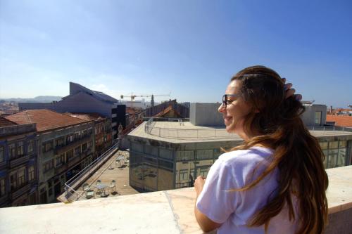 a woman standing on a ledge looking out over a city at WOT Porto in Porto