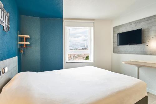 a bedroom with a white bed and a window at ibis budget Bordeaux Centre - Gare Saint Jean in Bordeaux
