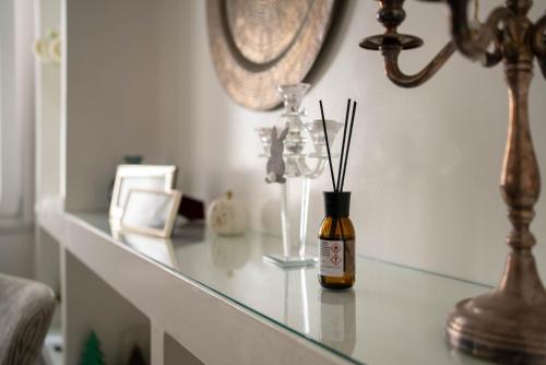 a glass counter top with a vase with sticks in it at La Casetta di Ceci in Vibonati