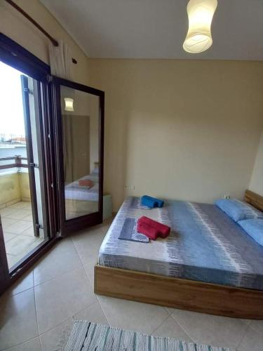 a bedroom with a large bed and a mirror at Anzhela apartment in Nea Roda