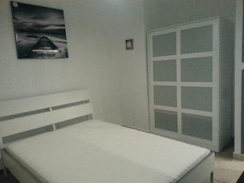 a white bedroom with a bed and a window at Residence La Phalene Elodie in Toulon