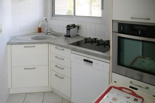 une cuisine avec un évier et une cuisinière dans l'établissement Charmant F5 à Saint Raphaël, à Saint-Raphaël