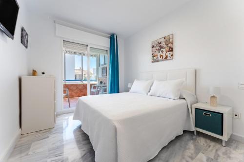 biała sypialnia z białym łóżkiem i oknem w obiekcie Fuengirola Los Pacos Vistamar w mieście Fuengirola