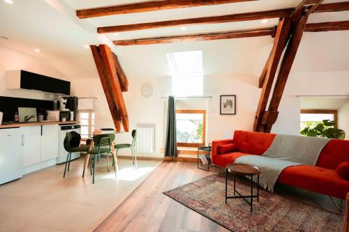un salon avec un canapé rouge et une cuisine dans l'établissement Studio 6 Centre Ville avec parking, à Aix-les-Bains