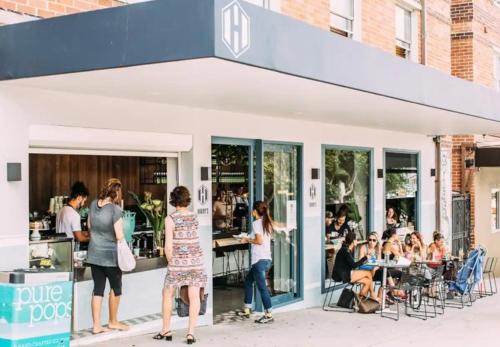 a group of people standing outside of a restaurant at Beachside bright unit - sleeps 4! in Sydney