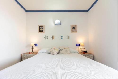 a bedroom with a white bed with two pillows at Apartamentos El Puerto, La Savina in La Savina