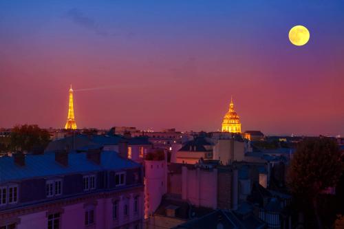 Blick auf eine Stadt bei Vollmond in der Unterkunft Eiffel tower view and terrace in Paris