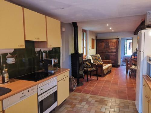 une cuisine avec des armoires jaunes et un salon dans l'établissement Ferme Les Serieges, à Villenouvelle