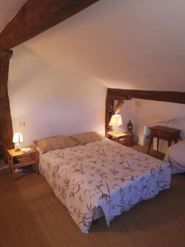 - une chambre avec un grand lit et 2 tables dans l'établissement Ferme Les Serieges, à Villenouvelle