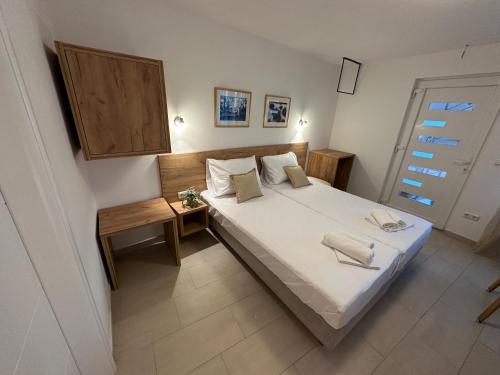 a bedroom with a large white bed and a table at A-Rooms Serviced Accommodation in Mostar in Mostar