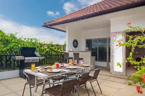 un patio con tavolo, sedie e griglia di Puri Temple Villa a Canggu