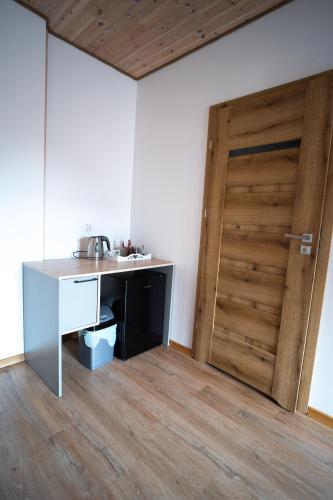 a kitchen with a desk and a wooden door at Pokoje Gościnne Fuksja in Nowęcin