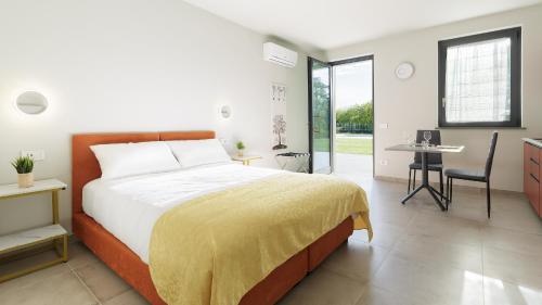 a bedroom with a bed and a table and a desk at Casale Auriga - Oltrepo' Pavese in Codevilla