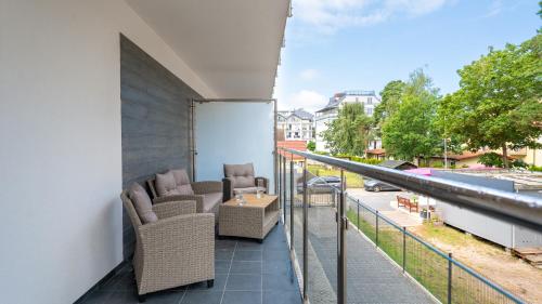 a balcony with chairs and tables on a building at Horizon Park II, Sun & Snow in Dziwnówek