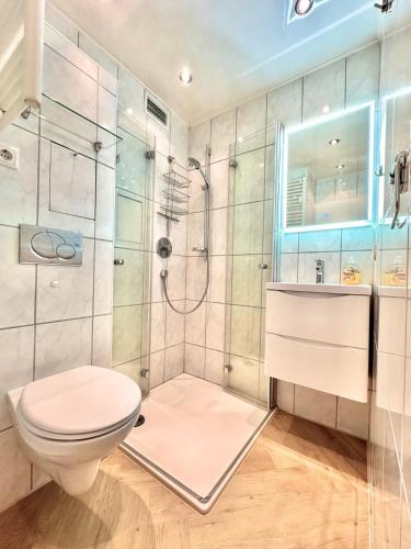a bathroom with a toilet and a shower at FeWo Traumblick - Himmel & Meer - TRAUM Panorama Meerblick, direkt am Strand mit großem Balkon in Sierksdorf