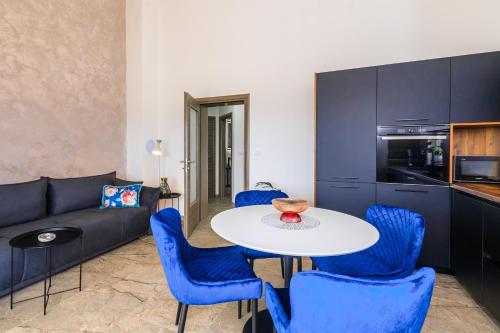 a living room with a table and blue chairs at PERLA VERDE Apartments in Krk